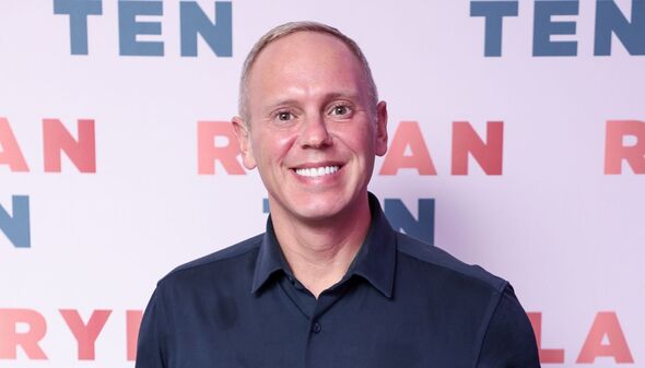 Close up of Rob Rinder smiling widely at an event