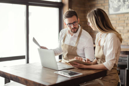 Two cafe owners looking at business loan options