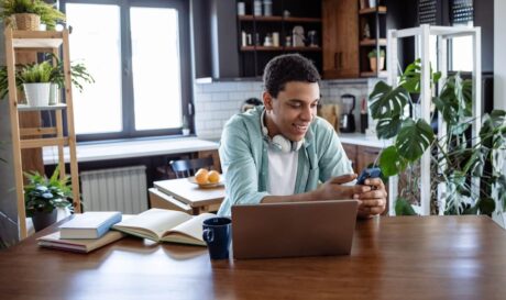 Man in a cafe using his laptop to look at ways to make money online