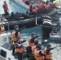 In this handout image provided by Armed Forces of the Philippines, Chinese Coast Guard hold knives and machetes as they approach Philippine troops on a resupply mission in the Second Thomas Shoal at the disputed South China Sea, on June 17, 2024. (Armed Forces of the Philippines via AP)