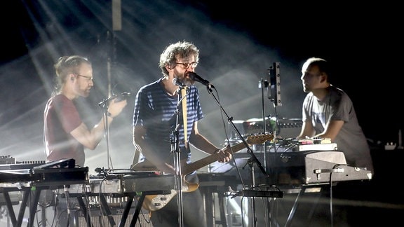 The Notwist, drei Männer an Instrumenten auf der Bühne.