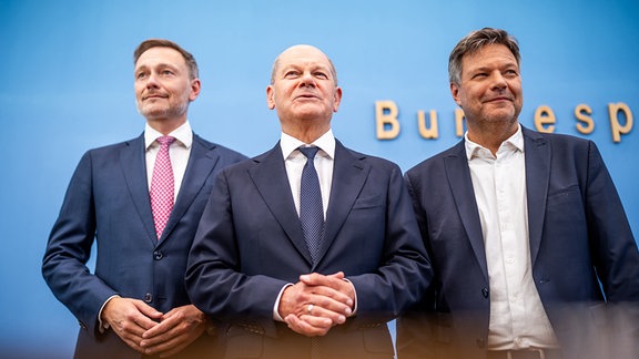 Bundeskanzler Olaf Scholz (SPD,M) Robert Habeck (Bündnis 90/Die Grünen , r), Bundesminister für Wirtschaft und Klimaschutz, und Christian Lindner (FDP), Bundesminister der Finanzen, nehmen an einer Pressekonferenz zum Haushaltsplan 2025 teil.