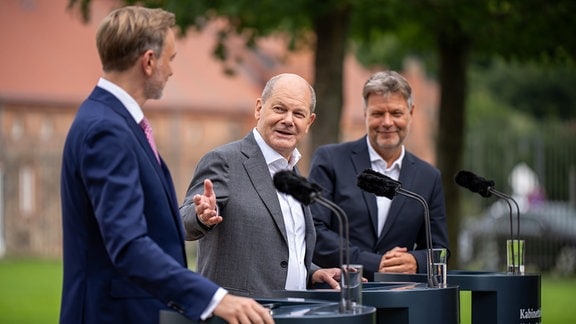 Bundeskanzler Olaf Scholz (SPD, M), Christian Lindner (FDP, l), Bundesminister der Finanzen,und Robert Habeck (Bündnis 90/Die Grünen), Bundesminister für Wirtschaft und Klimaschutz, nehmen am Pressesstatement nach der Halbzeit-Klausur des Bundeskabinetts vor Schloss Meseberg teil. 