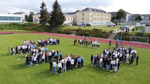 Menschen stehen auf einem Sportplatz