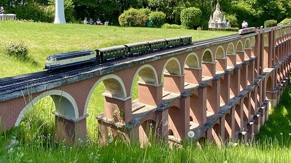 Miniatur der Gölschtalbrücke mit einem Modellzug darauf und einer Miniatur des Berliner Fernsehturms im Hintergrund