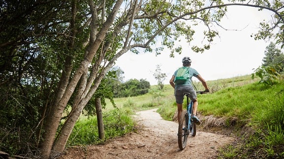 Mann fährt Mountainbike.