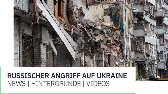 Rettungskräfte beseitigen Trümmer und suchen nach Menschen in einem Wohnblock, der von einer Rakete getroffen wurde.