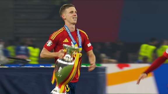 Fußballspieler Dani Olmo mit dem Pokal der Fußball EM 2024