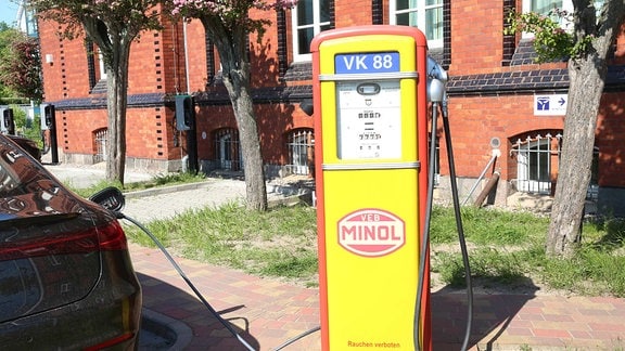 Ein Pkw wird an der ehemaligen Kraftstoffsäule einer Minol-Tankstelle geladen