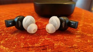 Final ZE8000 MK2 in-ear headphones with ear-tips attached on read cloth surface