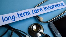 The words long-term care insurance on a white banner over the top of a stethoscope against a blue background.