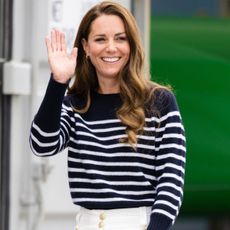 Kate Middleton smiles and waves wearing a striped sweater