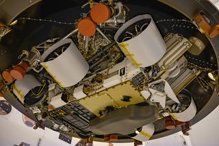 Seen from below, NASA's Mars 2020 Perseverance rover bears a plaque to the right of its middle wheel. Featuring a snake-entwined rod to symbolize healing and medicine, it commemorates the impact of the COVID-19 pandemic and honors the perseverance of healthcare workers around the world.