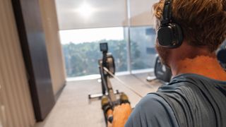 A man exercising on a rowing machine at home