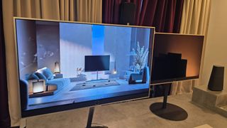 Loewe Stellar TV on a floor stand with a modern living room on screen
