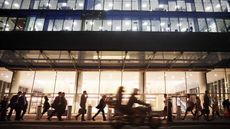 city office building at night with lots of people walking in front