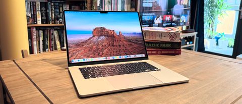 The 2024 MacBook Air M3 on a wooden table in front of a bookshelf.