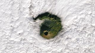 In this image captured Jan. 2 by the Landsat 8 satellite Mount Vesuvius is clearly visible through a circular hole in the clouds.