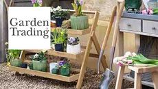 The Garden Trading logo over an image of some garden furniture and plants