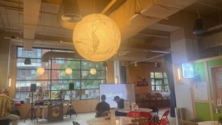 Inside of Reading Biscuit Factory with tables, DJ set and giant globe light