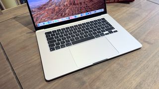 The 2024 MacBook Air M3 on a wooden table in front of a bookshelf.