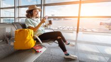 A woman sits at an airport gate.