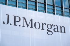 A large banner with the words "J.P. Morgan" handing on windows outside of J.P. Morgan headquarters in London.