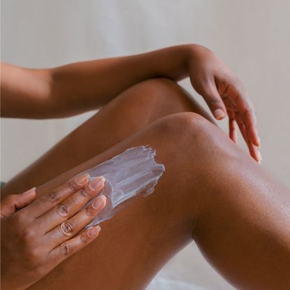 a woman rubbing a best body cream for dry skin Getty Images 1653185592 