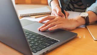 Student using one of the best macbooks for students and taking notes