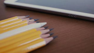 Apple Pencil laying beside wooden pencils. 