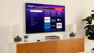 Roku Pro Series TV wall-mounted above a wooden console