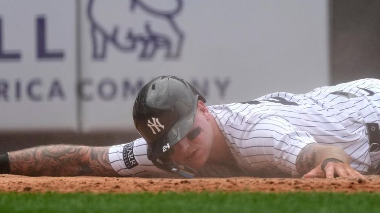 New York Yankees' Alex Verdugo lays on the ground after...