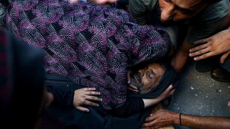 Relatives mourn over the body of a Palestinian man killed...