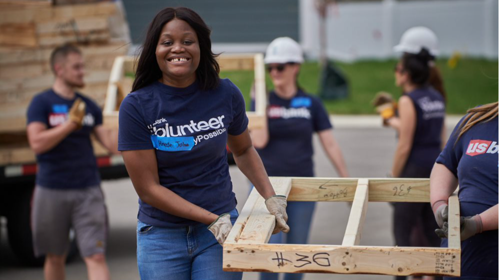 Image two people smiling with volunteer t-shirts