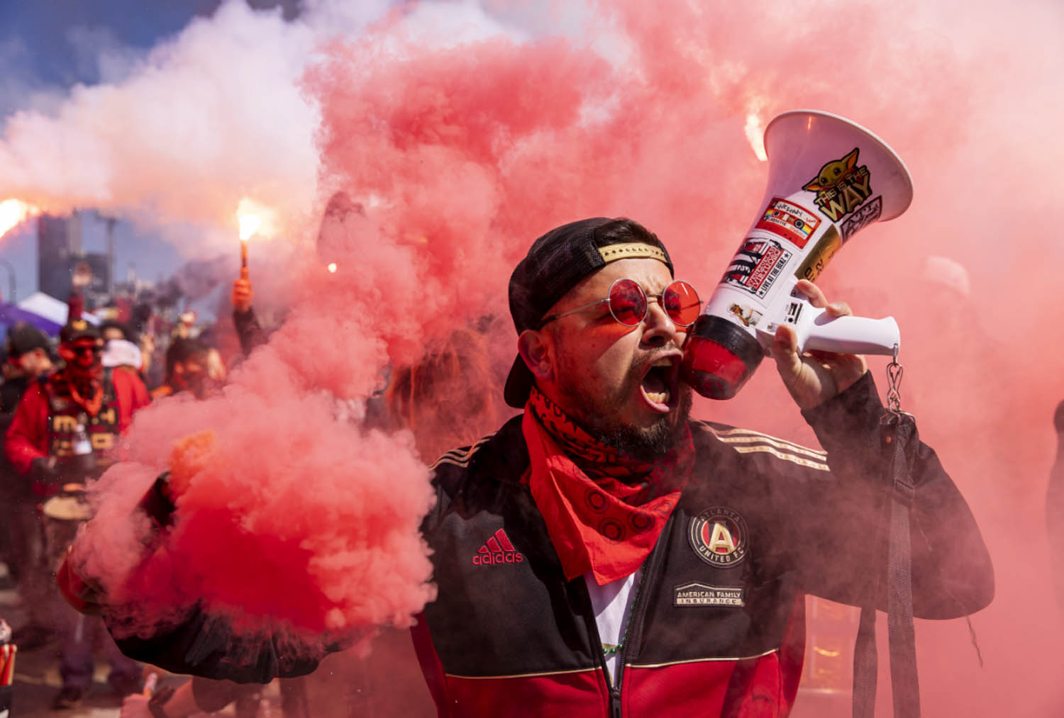 Atlanta United fan yellow in mic with red smoke