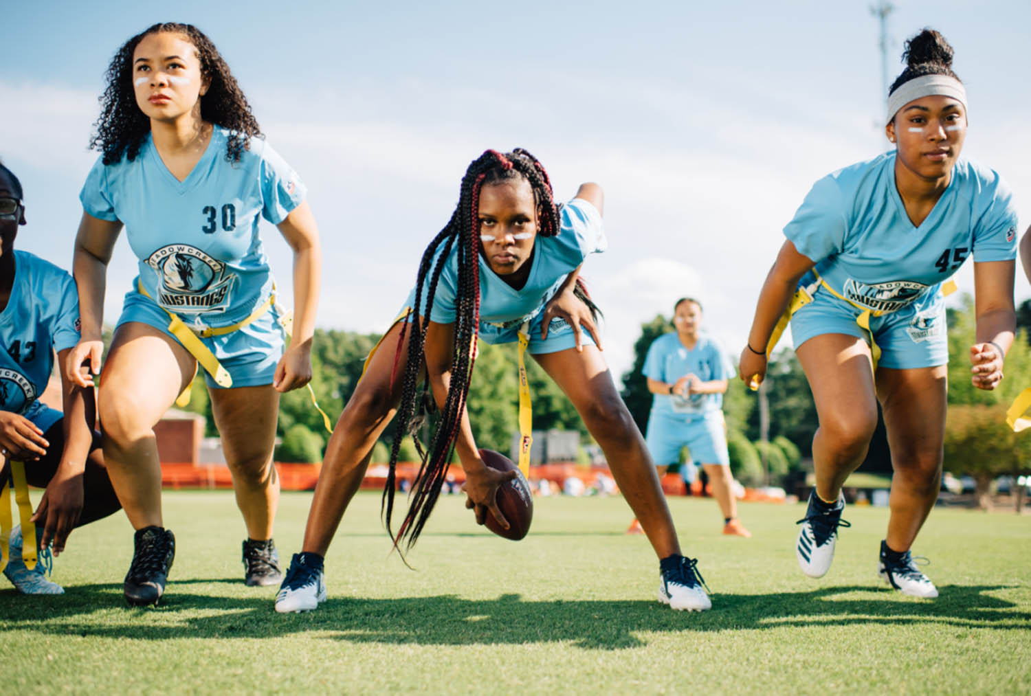 3 girls playing girls flag football