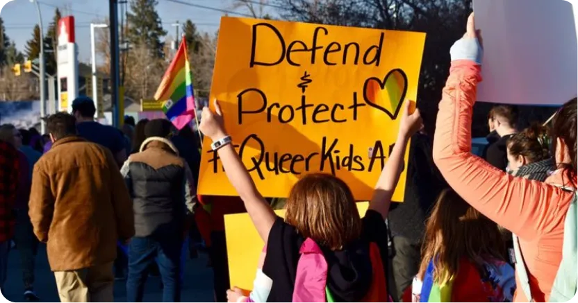 Teen standing in crowd holding sign