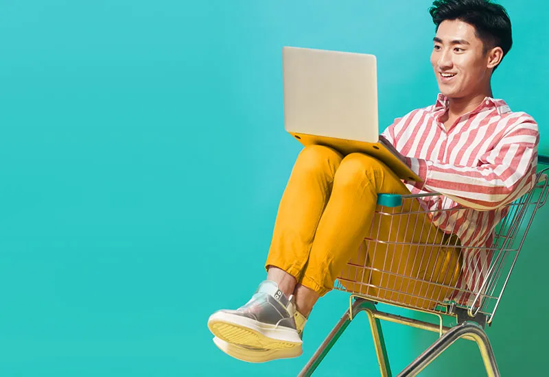 Man browsing on the web in a shopping cart