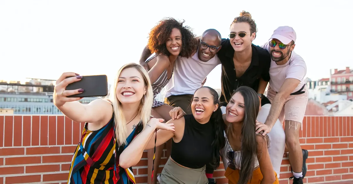 Groupe d'adultes de la Gen Z prenant un selfie contre un mur de briques