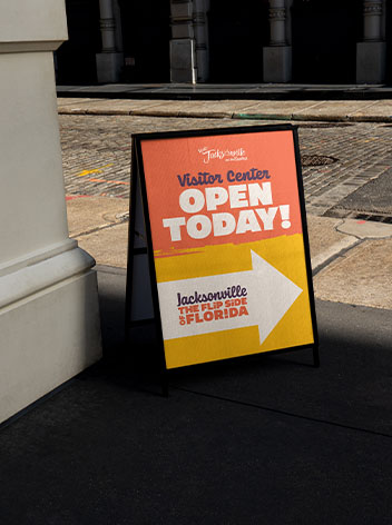 A A-frame sign on the sidewalk featuring Visit Jacksonville