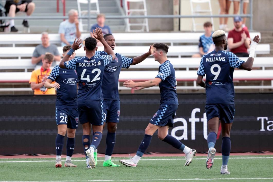 Five Indy Eleven players celebrate on the field during a match