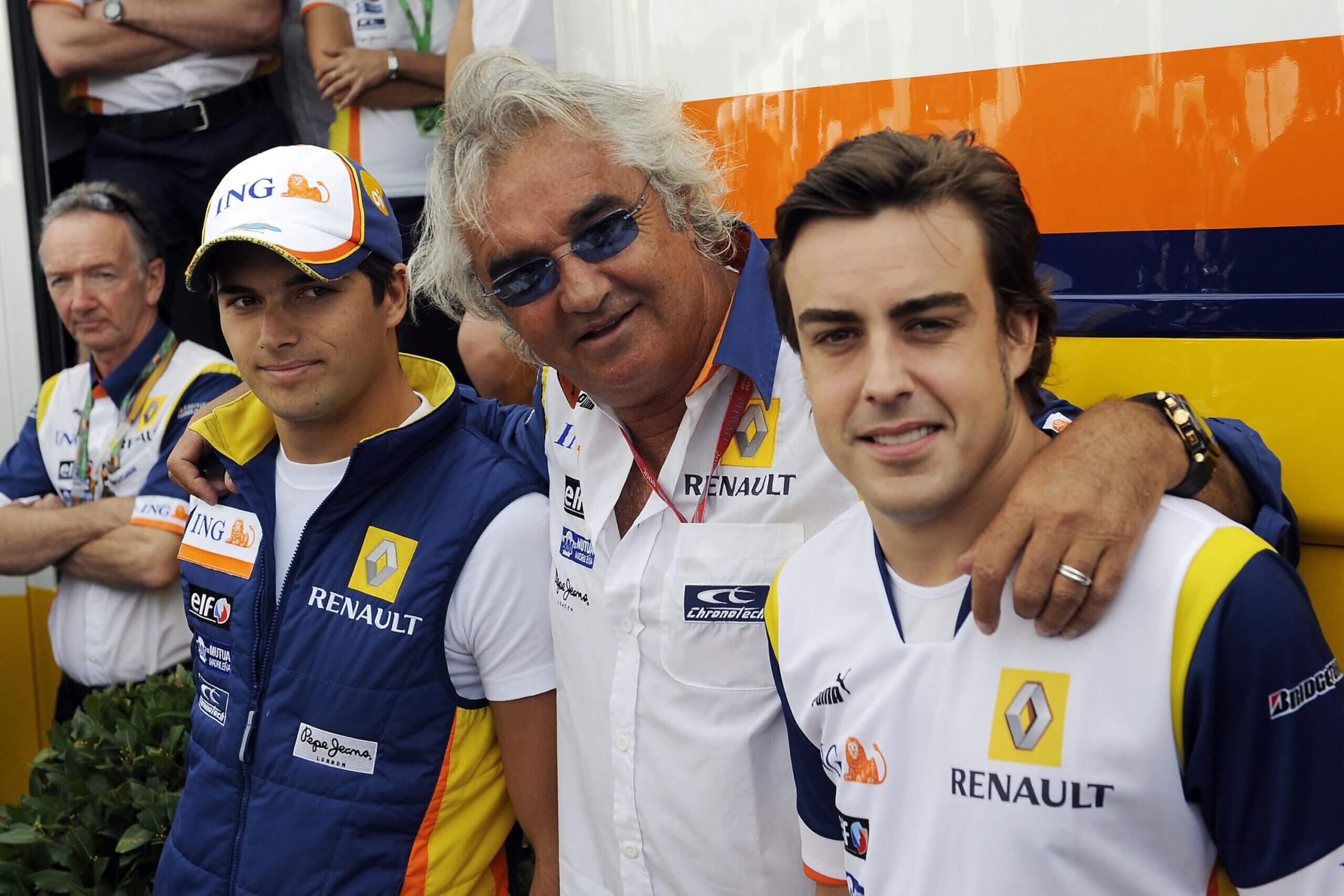 Renault's drivers Spanish Fernando Alonso (R) and Brazilian Nelsinho Piquet (L) pose with Renault's team chief Flafio Briatore as they celebrate both drivers birthday in front of Renault Formula One team's motorhome at the Hockenheim ring racetrack on July 20, 2008 in Hockenheim, prior the German Formula One Grand Prix. AFP PHOTO / Oliver Lang (Photo credit should read OLIVER LANG/AFP via Getty Images)