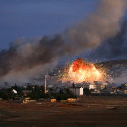 Fire and smoke rise from city buildings.