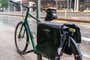 A bike resting against a street sign on a rainy day.