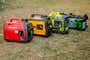 Four portable generators side-by-side on a grassy lawn