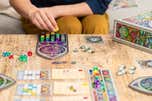 A person playing Sagrada, a board game we recommend, showing the game set up for play on a table.