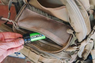 A small cylindrical water filter in a backpack pocket