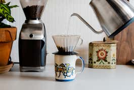 A large vintage mug with a pour over coffee dripper sitting on top of it.