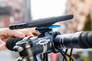 Close view of a smart phone attached to the handlebars of a bike using a bike phone mount.