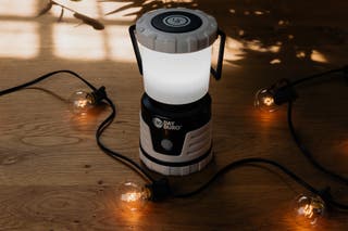 A black UST 30-Day Duro Lantern on the floor amongst a string of lights.